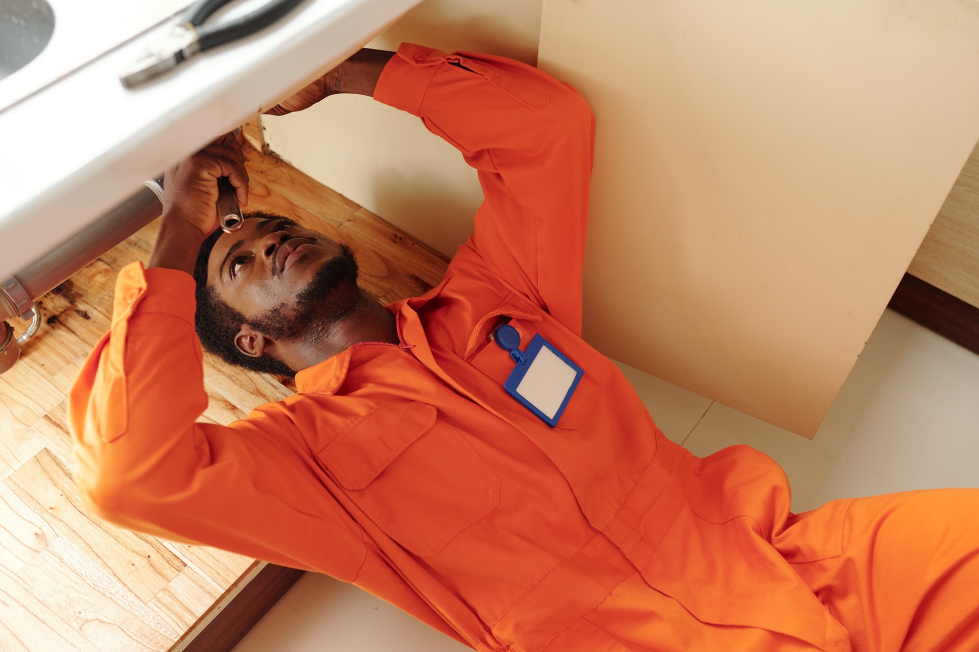 Black plumber fixing clogged drains